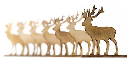 Cut out deer figure made of wood with dark edges and wooden fir trees photo