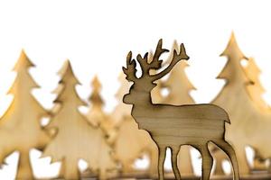 Cut out deer figure made of wood with dark edges and wooden fir trees photo