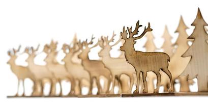 Cut out deer figure made of wood with dark edges and wooden fir trees photo