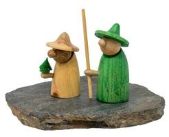 Two wooden christmas figure stand on a dark wooden board photo