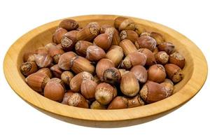 Turned brown wooden bowl with hazelnuts isolated on white photo