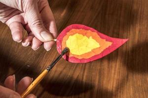 Christmas crafts  painting a handmade candle flame for a decoration photo