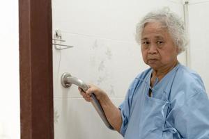 Asian senior or elderly old lady woman patient use toilet bathroom handle security in nursing hospital ward photo