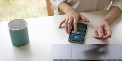 Mano de mujer de negocios usando pagos de tableta de teléfono inteligente y sosteniendo tarjeta de crédito compras en línea omni channel tableta digital teclado de acoplamiento computadora en la oficina a la luz del sol foto