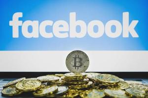 CHIANG MAI, THAILAND, JUNE 19, 2019,  Facebook logo on screen and bitcoin coins photo