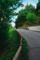 road with green trees in the mountain photo