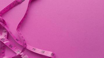 Pink centimeter on pink background Simple flat lay with pastel texture Fitness concept Stock photo
