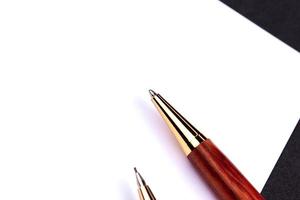 Luxury pen and mechanical pencil in wood and gold with a white sheet of paper photo