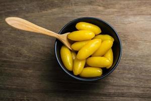 Thai traditional desserts Mung bean paste formed in egg yolk and sugar in black small bowl on the Wooden top table photo