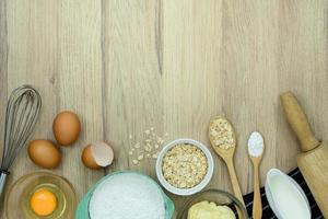 Top view with copy space of tools and ingredients for baking cake on wooden background photo