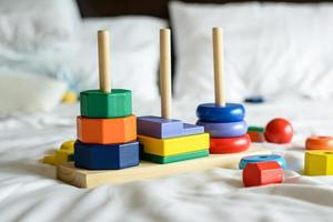 wooden colorful blocks and sorting shapes on the bed photo