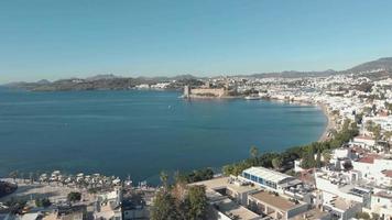 Seaside marina of Bodrum with castle of St. Peter in sight in Aegean Region of Turkey - Panoramic aerial video