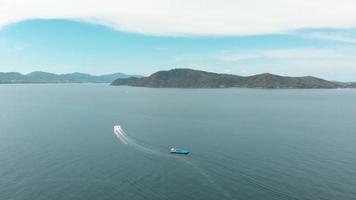Speed Boat cruising through the waters between Koh Hey, Coral Island, and mainland Phuket, Thailand - Aerial wide panoramic shot