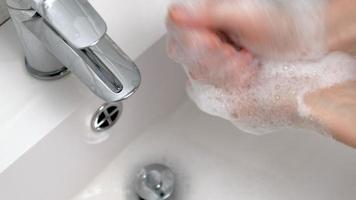 uma mulher lava as mãos com sabonete no banheiro video