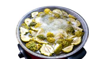 Boil the kaffir lime peel in an electric pan isolated on white background photo