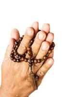 hands of old aged human were binded by wood rosary on white background  isolated photo