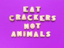Eat crackers not animals Food typography on pink background Vegan concept Stock photo