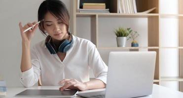 Mujer sentada ues portátil pensando en la solución del problema pensativa empleada reflexionando considerando la idea mirando la pantalla de la computadora tomando decisiones foto