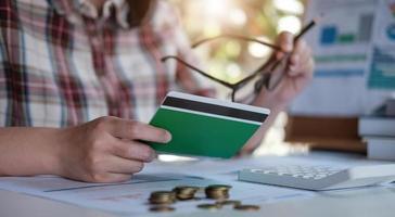 Joven mujer asiática comprobando facturas impuestos saldo de cuenta bancaria y calculando gastos de tarjeta de crédito concepto de gastos familiares foto