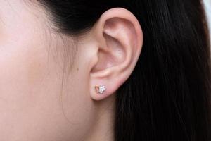 Diamond earring on the ear of an Asian woman photo