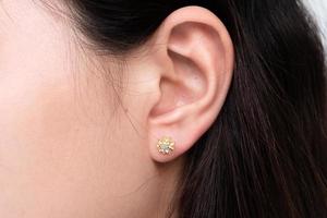 Diamond earring on the ear of an Asian woman photo