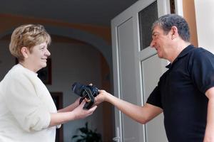 Women greeting men at doorway photo