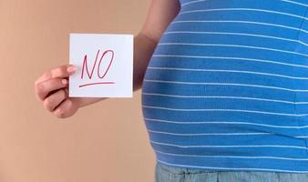 Una vista de cerca del vientre de una mujer embarazada con la palabra no foto