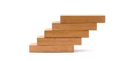 Apilamiento de bloques de madera como escalera sobre fondo blanco.