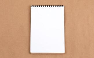 Flat lay top view photo of blank notepad on a beige abstract background with copy space