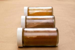 Three jars of seasoning on a brown background with selective focus photo