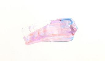 Una espátula de pintura aislada sobre un fondo blanco con rosa y violeta foto