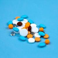 Multi colored pills on a blue background close-up photo