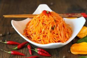 Carrot Korean meat salad with chopsticks on wooden oak table photo