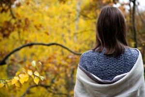 Rear view from the back of a girl looking at the forest with yellow leaves photo