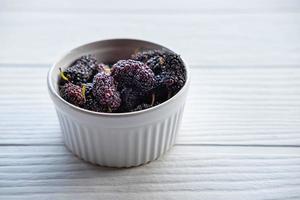 Fresh mulberry in a bowl on the table photo