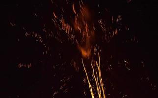 Fuegos artificiales naranjas en el cielo durante la noche. foto