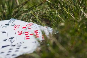 Playing cards in green grass close up photo