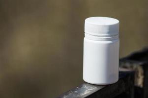 White  pills lie on a metal railing photo
