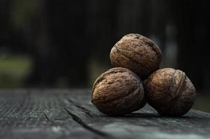 Nueces marrones sobre una tabla de madera oscura. foto