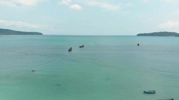 Panoramablick auf die umlaufende Bucht, bevölkert von Fischerbooten, die über dem türkisfarbenen Meer in der sarazenischen Bucht in Koh Rong Sanloem, Kambodscha, festgemacht sind - Panoramablick aus der Luft video