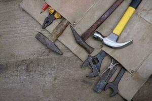 Collection of woodworking old hand tools in leather apron on a rough wooden workbench photo