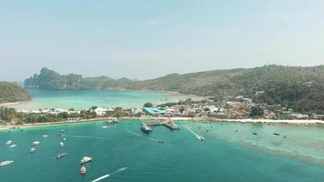 Vista superior del ajetreado tráfico de barcos del muelle de Ton Sai y el paraíso de la bahía de Ton Sai en la isla de Ko Phi Phi Don, Tailandia - Sobrevuelo aéreo video