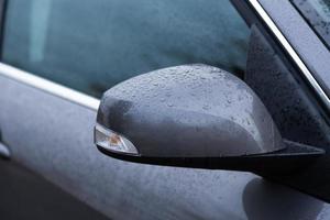 Rear view mirror of car wet from drops of water photo