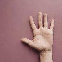 hand gesturing on the pink wall photo