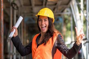 dando el signo v en el sitio de construcción foto