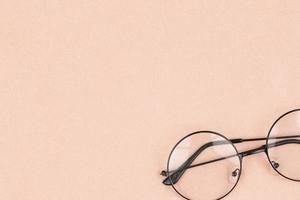 Round hipster sunglasses on pink background photo