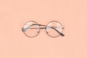 Round hipster sunglasses on pink background photo