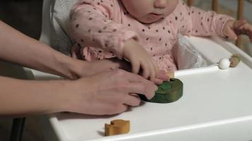 Little girl is playing with a wooden toy The development of fine motor skills video