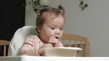 Little toddler girl eating porridge