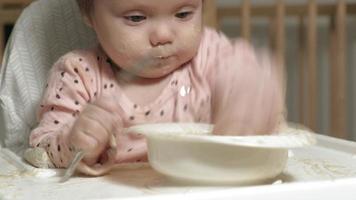 Little toddler girl eating porridge